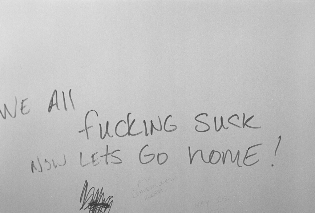 We All Fucking Suck On A Bathroom Wall