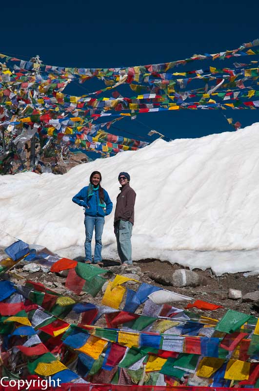 Travellers pause amidst prayer flags at the Khardung La