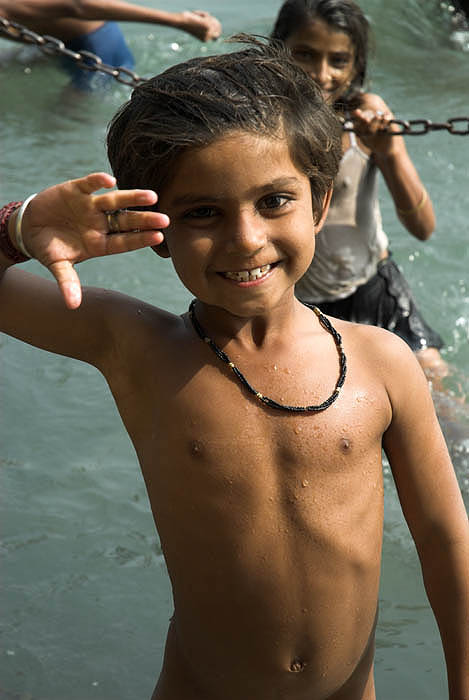 Children swim for coins in the Ganges, India