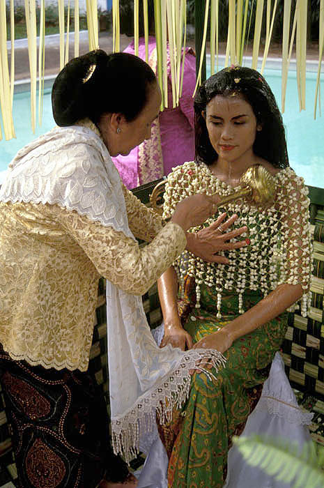 Javanese bride undergoes the Midarodeni or washing ceremony