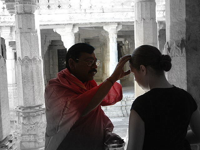 Aven receiving a blessing from the priest at the Jain temple