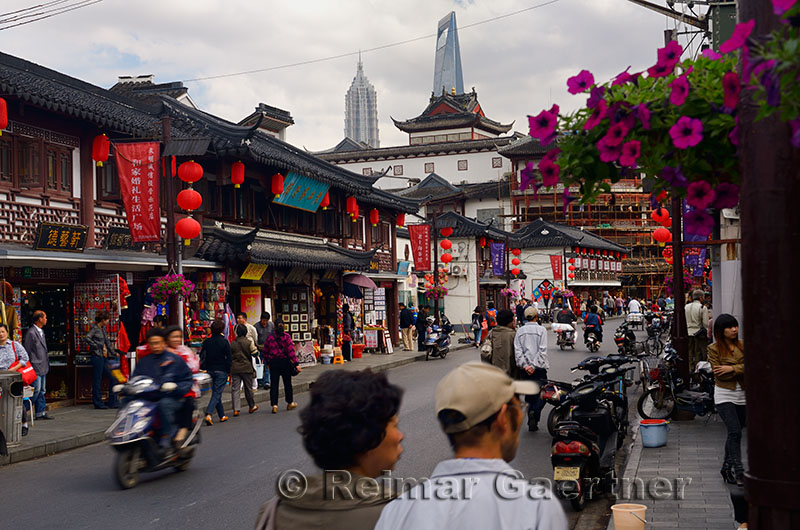 Fangbang Zhong road with shops pedestrians and motorcycles in Hangpu District Shanghai China