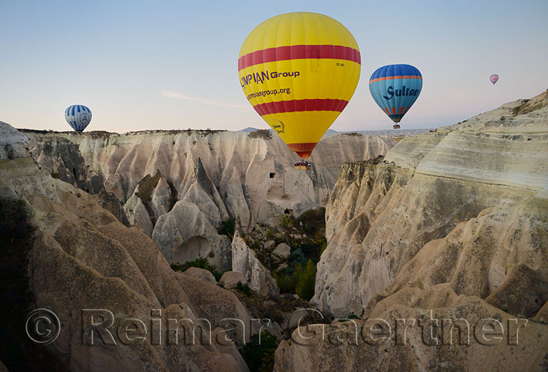 Hot air balloon over a steep canyon of eroded volcanic tuff in Cappadocia Turkey
