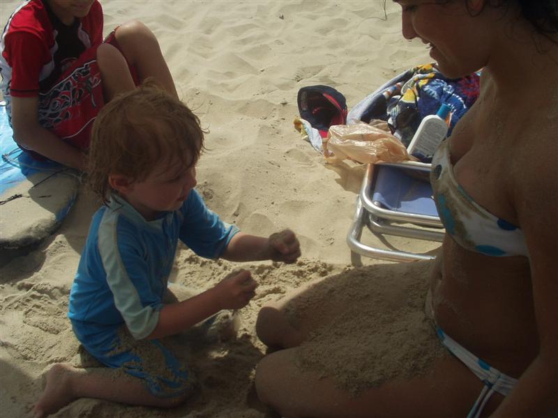 Jessie covers renee with sand.