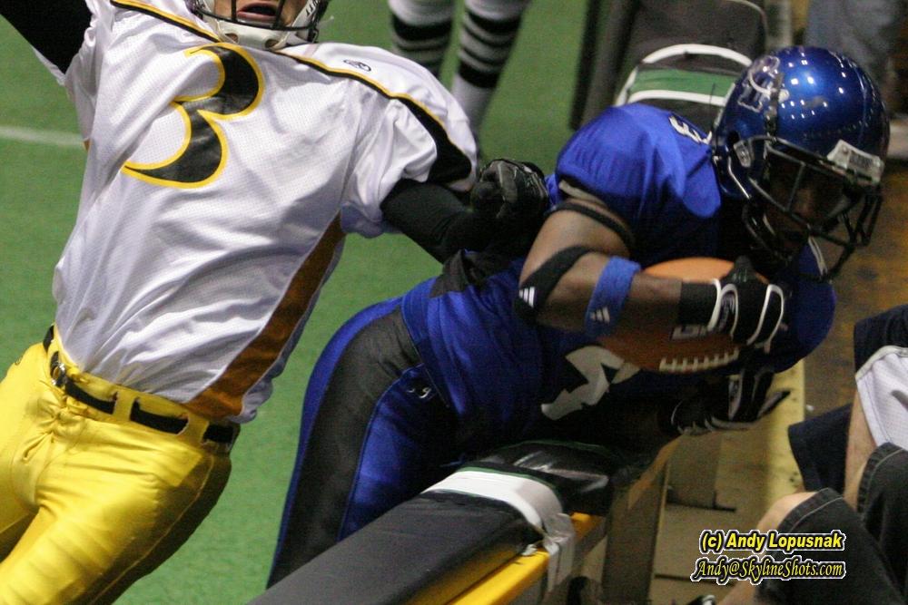 Michigan Pirates RB Robert Height gets slammed into the boards after a touchdown