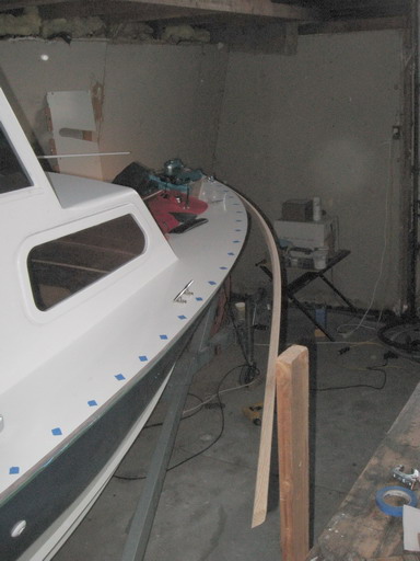 Blue tape marks hidden screw; 2 x 4 holds piece for bending and fitting.