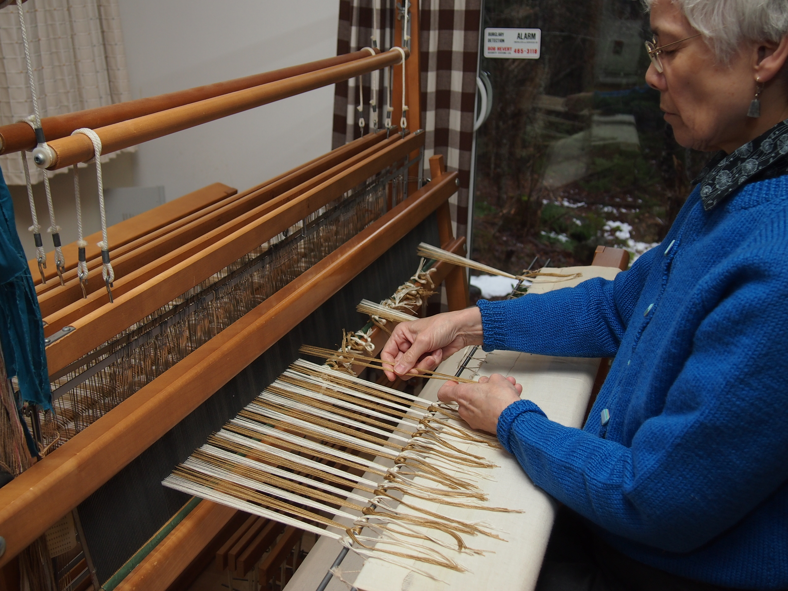 Warp being tied onto cloth beam.