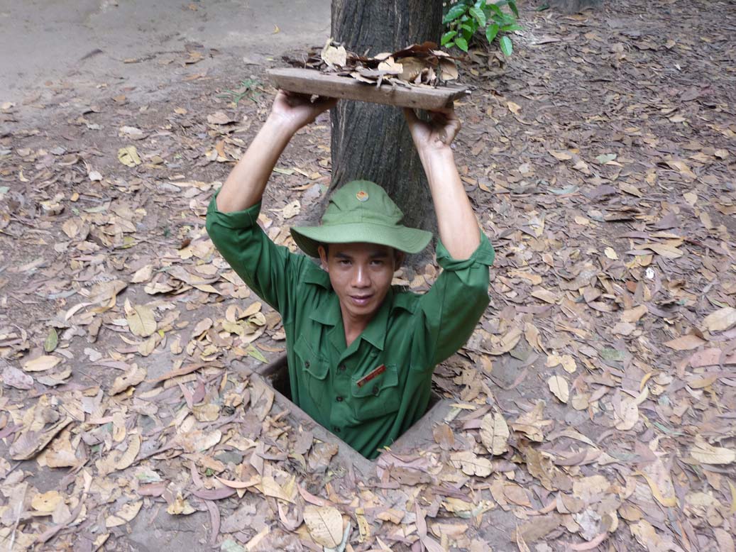 This guide, who was dressed up like a Vietcong soldier, was demonstrating an entrance to the tunnels.