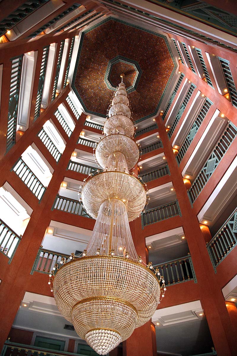 This is looking up in the atrium of a hotel at a massive chandelier