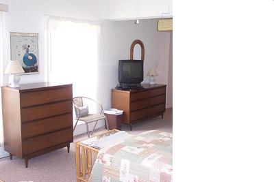 TV with DVD/VCR is on turntable, visible from both sides. Each side is furnished with dresser, table, lights.jpg