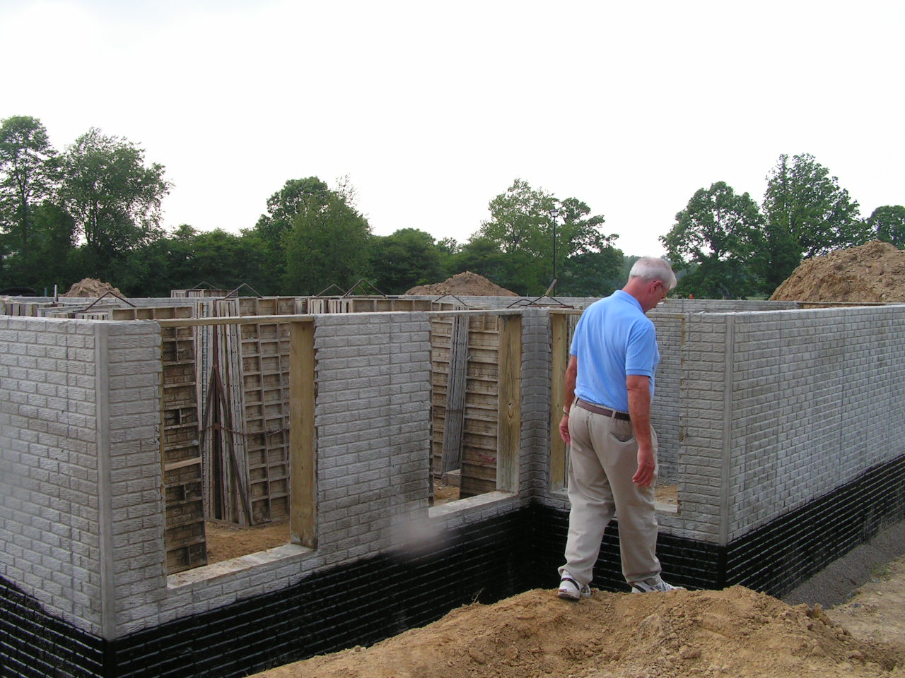Chris surveys the foundation in late May.  Now it has to cure for at least a month.JPG