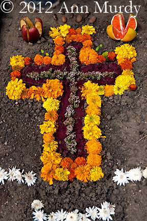 Decorated grave with marigolds and grapefruit
