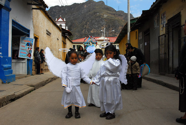 The procession is led by 3 little kids dressed as angels