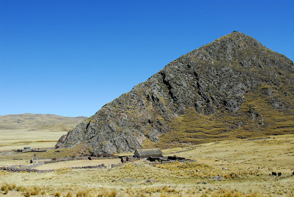 Rocky peak rising from the Altiplano north of Ayaviri, Peru
