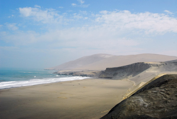 Broad, flat beach with major dunes and cliffs behind it