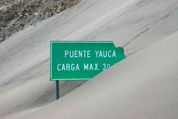 Sign losing out to sand dunes, Yauca, Peru