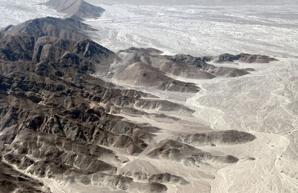 Rocky hills rising out of the Nazca desert