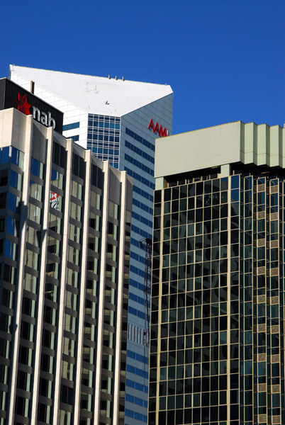 The top of the AAMI Tower behind other buildings, Brisbane