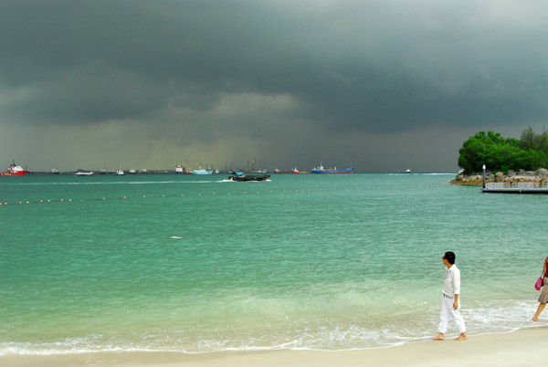 Walking the beach of Sentosa with ominous clouds in the sky