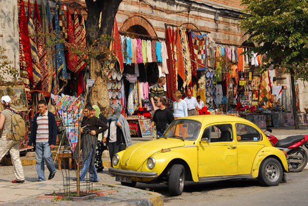 A yellow VW Beetle in front of a colorful Turkish market, Sultanahmet