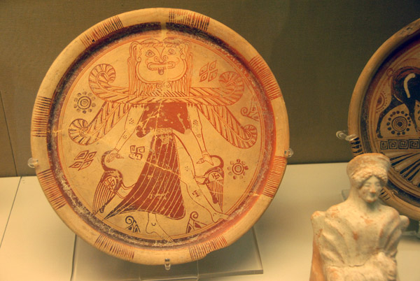 Plate with a winged goddess with a gorgon's head wearing a split shirt and holding a bird in each hand, Rhodes ca 600 BC