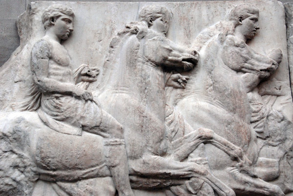Figure 26 of the Parthenon South Frieze X, a rider wearing a cuirass over a short tunic with cloak and riding boots