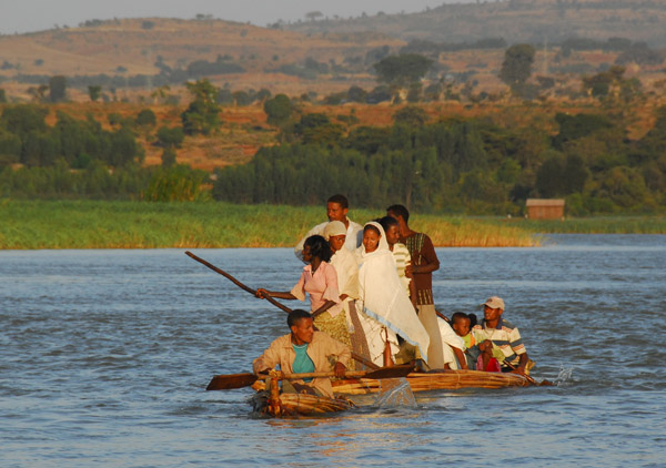 A larger reed boat with standing passengers