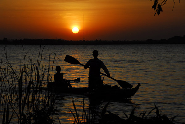 Two boys with reed boats in front of a Lake Tana sunset
