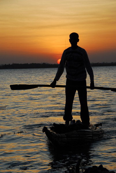 Boy standing on a reed boat, Lake Tana sunset
