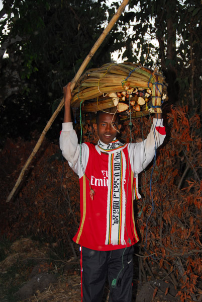 Ethiopian carrying a reed boat with a Fly Emirates shirt