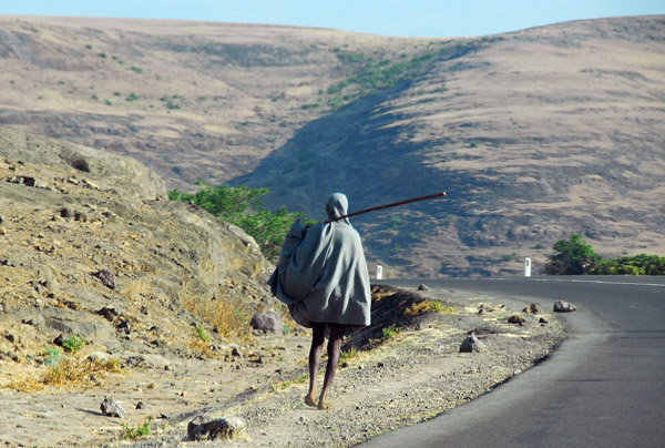 Ethiopian walking along the road with a staff
