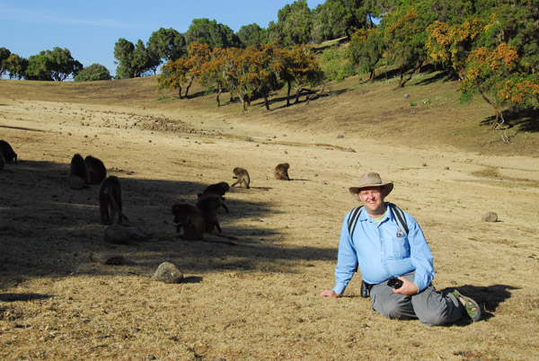 Keith with a troop of Gelada grazing in the shade