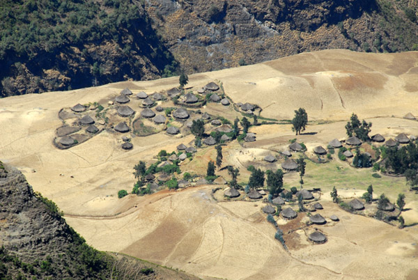 A large village with farmland below the cliffs of Chenek