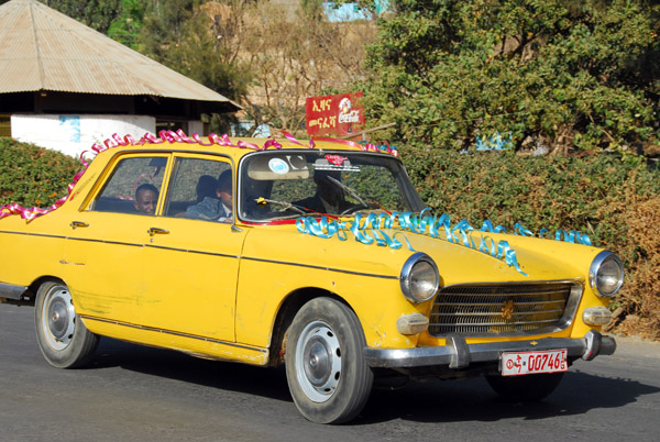An old yellow Peugeot decorated for another wedding