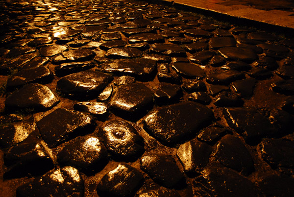 Wet paving stones of the ancient Roman road outside the Colosseum
