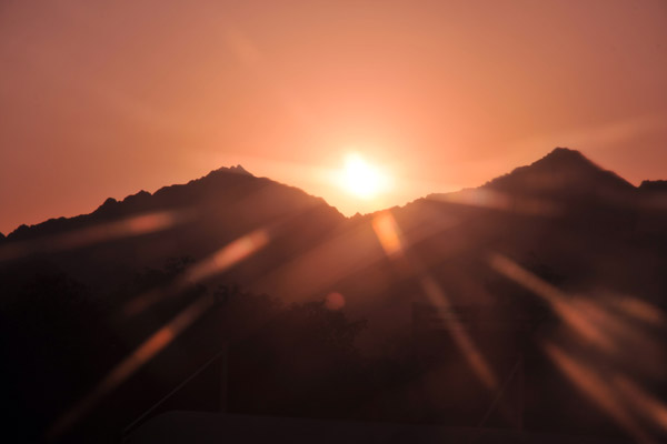 Sun setting behind the mountains from the Al Bustan Palace