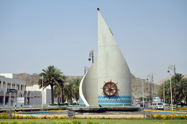 Roundabout art with a ship's steering wheel, Muscat