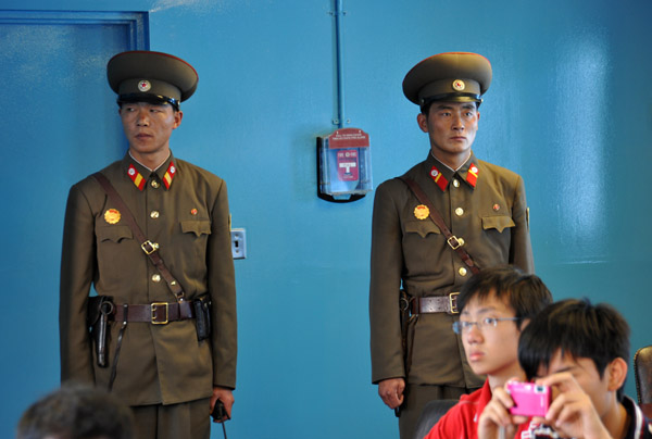 A pair of North Korean soldiers on ROK territory make sure no one leaves through the wrong door