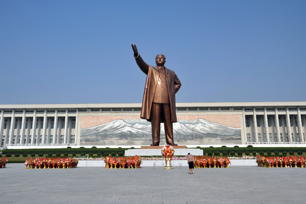 A lone woman bows in front of the statue of Kim Il Sung