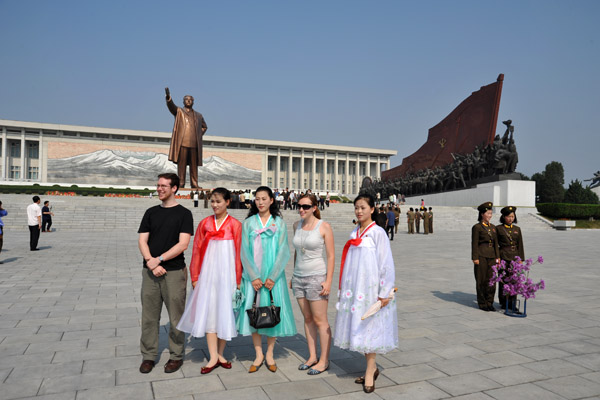 North Korean women posing with American tourists at the Mansu Hill Grand Monument