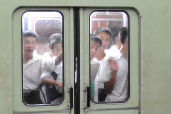 Curious North Koreans glancing out of a subway car