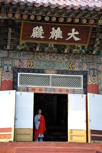 Monk waiting at the door of the Taeung Hall