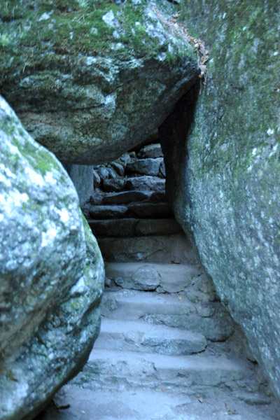 Carved steps leading under a boulder