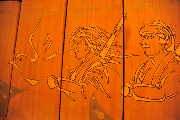 Kurdish mural - armed man and woman following a dove