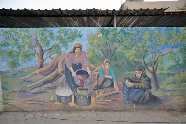Mural of Kurdish women preparing food over a campfire on the wall of Salahaddin University, Erbil