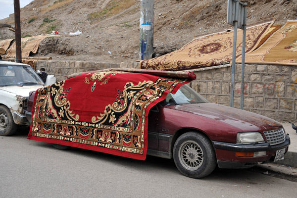 Car covered in a red carpet at the base of the Erbil Citadel