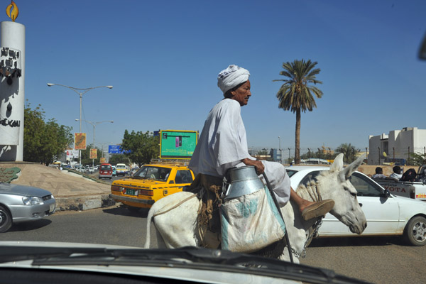 Man riding a donkey in Khartoum traffic