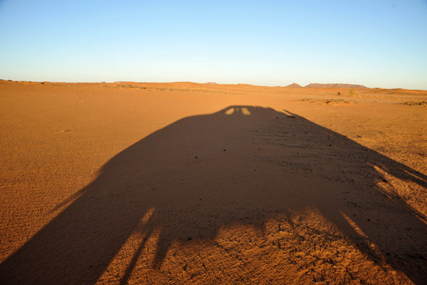 Long shadow of our truck as we search the desert for a good campsite