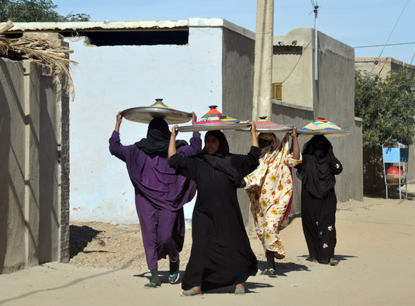 Sudanese women carrying trays of food, Kerma