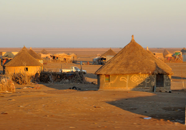 Village of thatched rondavels on the flat desert of Eastern Sudan